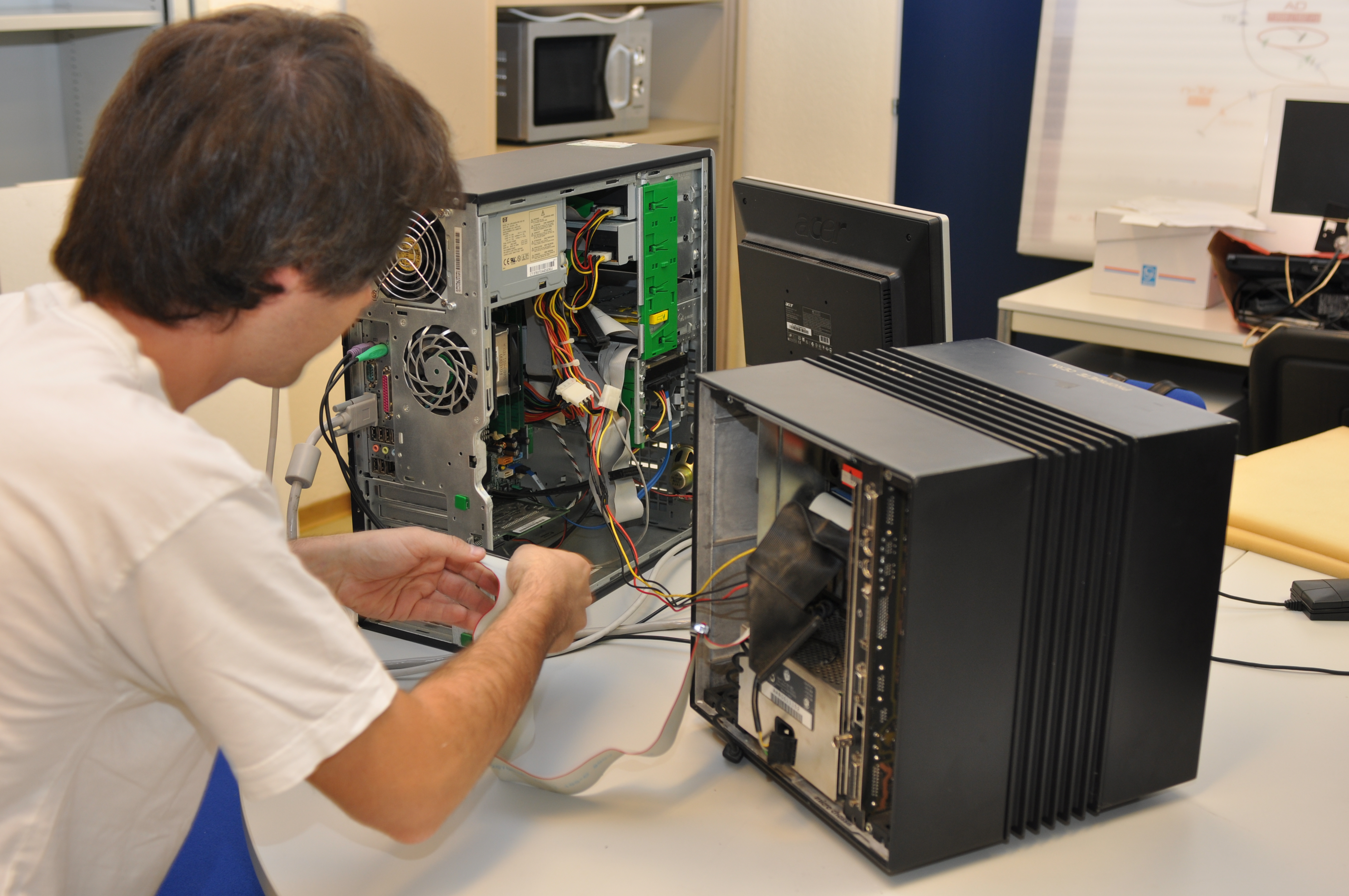Image of a technician working on connecting two open computers