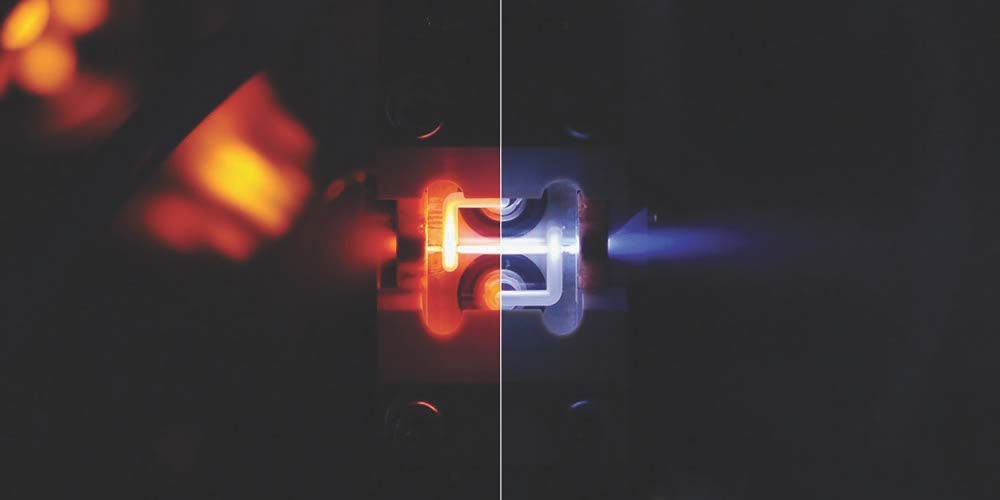 An active plasma lens during discharge in both helium (left) and argon (right). The image on the left is reddish-orange in colour while the one on the right is bluish. Image credit: K Sjøbæk/CLEAR
