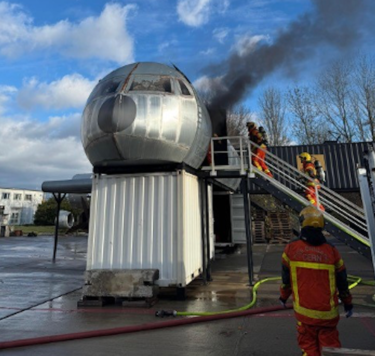 Firefighters practise putting out a fire in a mock aircraft