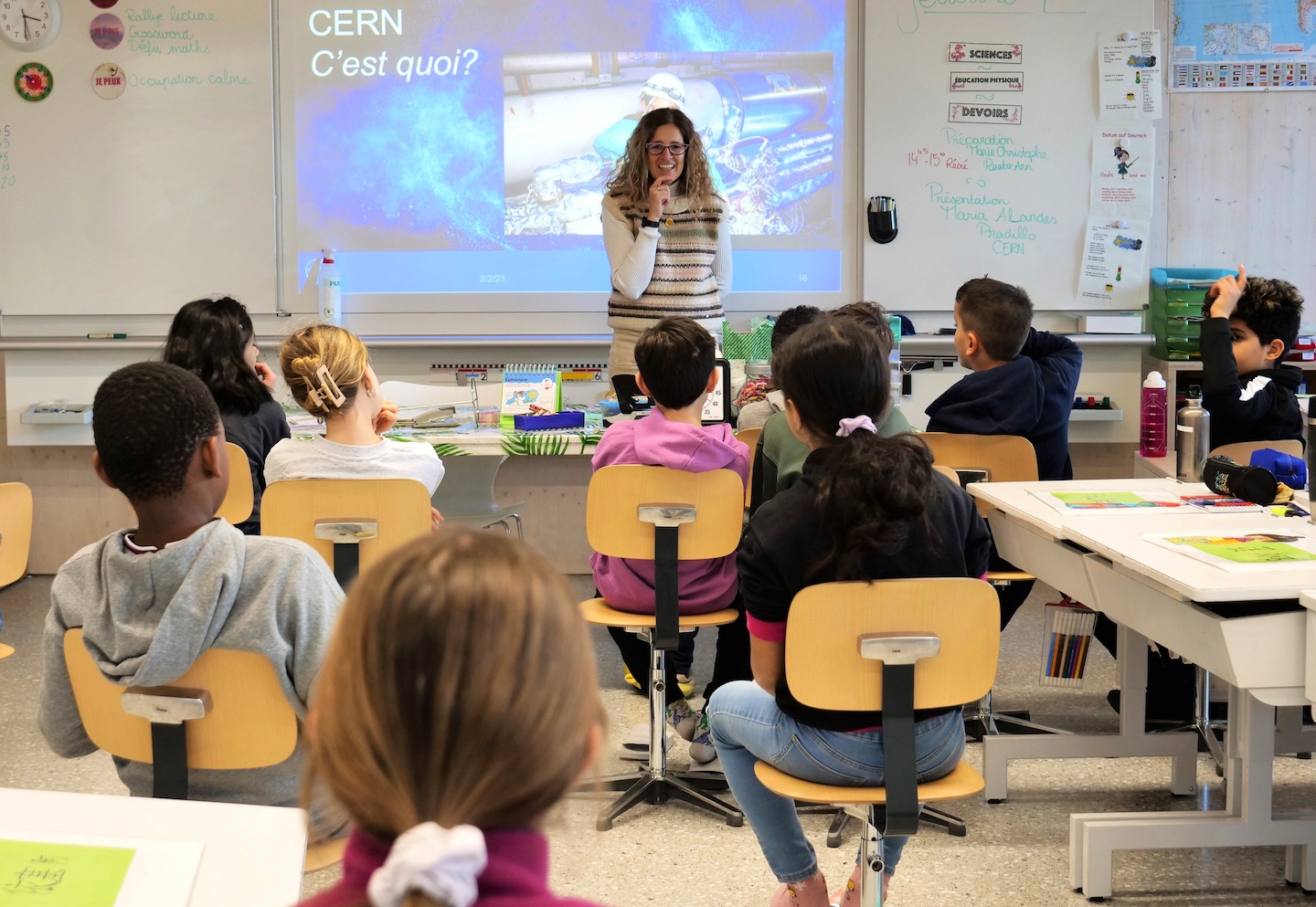 A woman gives a presentation in front of pupils.