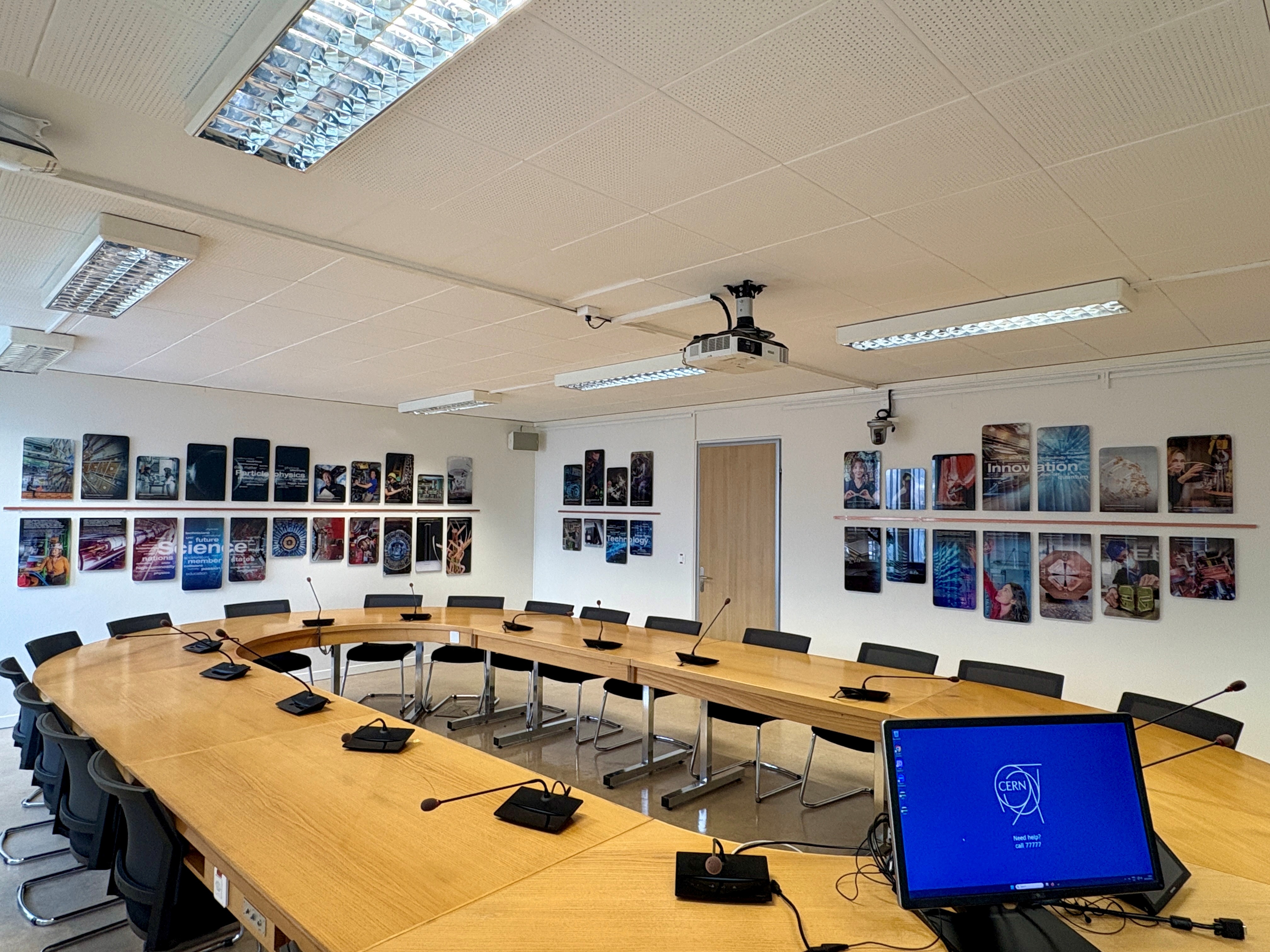 Meeting room table in foreground and photo display on the walls in the background