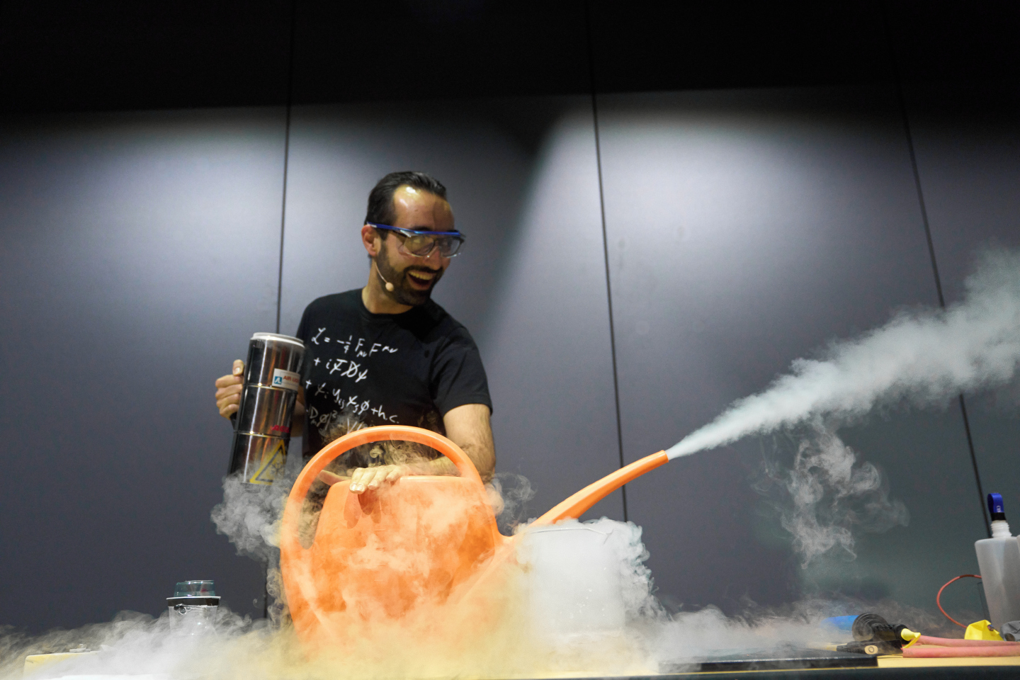 CERN-PHOTO-202311-276-13 CERN guide on stage excitedly showing vapour from liquid nitrogen shooting out of the spout of a watering can